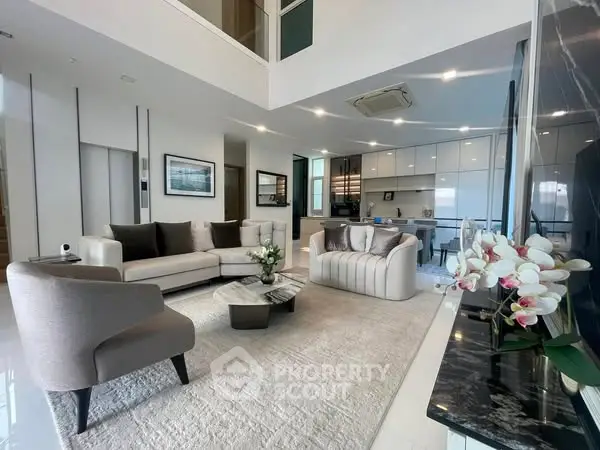 Luxurious modern living room with elegant furniture and open kitchen layout