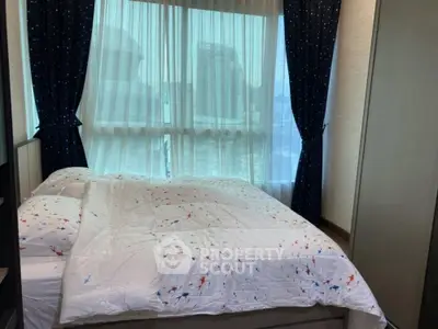 Cozy bedroom with large window and stylish curtains in modern apartment.