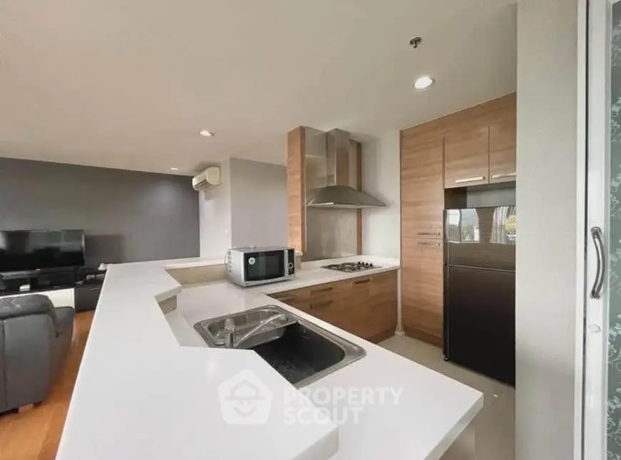 Modern open-layout kitchen with sleek appliances and spacious living area in a stylish apartment.