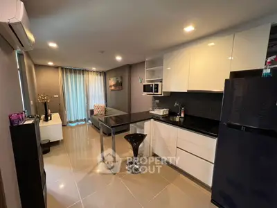 Modern open-layout kitchen with sleek appliances and cozy living area.