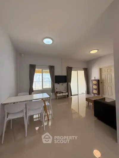 Spacious living room with modern furniture and natural light, perfect for family gatherings.