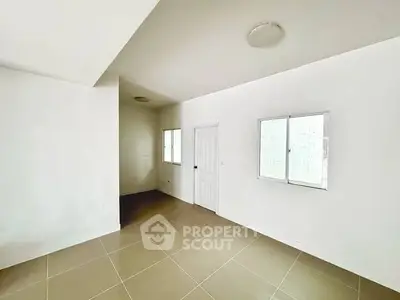 Spacious empty room with tiled floor and white walls, ready for customization.
