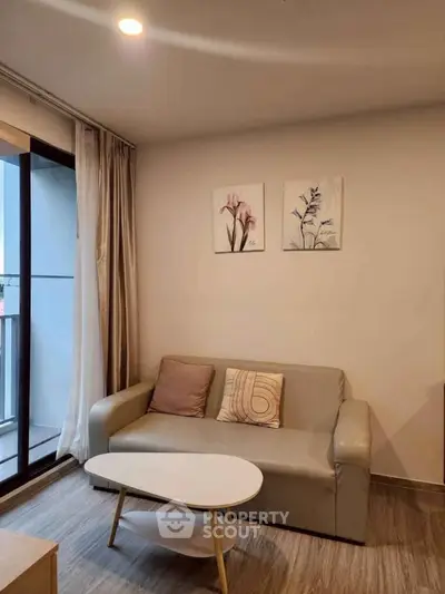 Cozy living room with modern decor and balcony access in a stylish apartment.