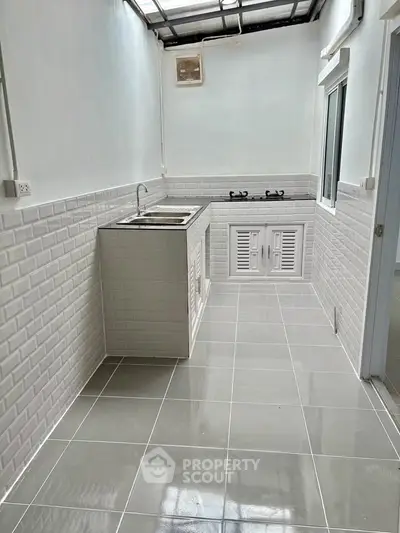 Modern kitchen with sleek white tiles and gas stove
