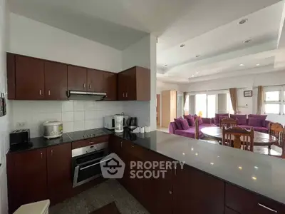 Spacious open-layout kitchen and living room with modern appliances and elegant dining area.
