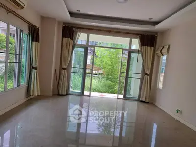 Spacious living room with large windows and garden view