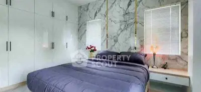 Luxurious bedroom with marble accent wall and modern furnishings