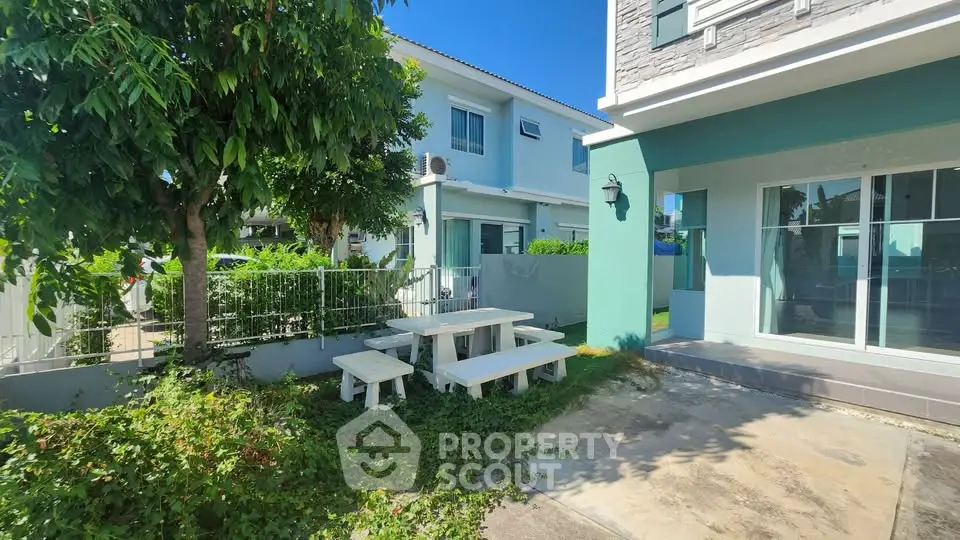 Charming suburban home with lush garden and outdoor seating area, perfect for relaxation and entertaining.