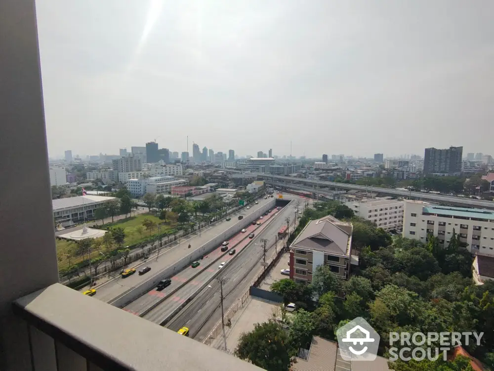 Stunning cityscape view from high-rise balcony overlooking bustling urban landscape.