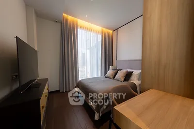Modern bedroom with large window and stylish furnishings in a luxury apartment.