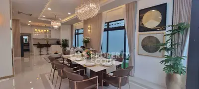 Luxurious open-plan dining and living area with elegant chandeliers and modern decor.
