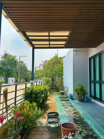 Charming outdoor garden with a modern patio and lush greenery, perfect for relaxation and entertaining.