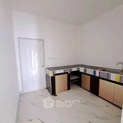 Modern kitchen with colorful cabinets and marble flooring in a minimalist design.