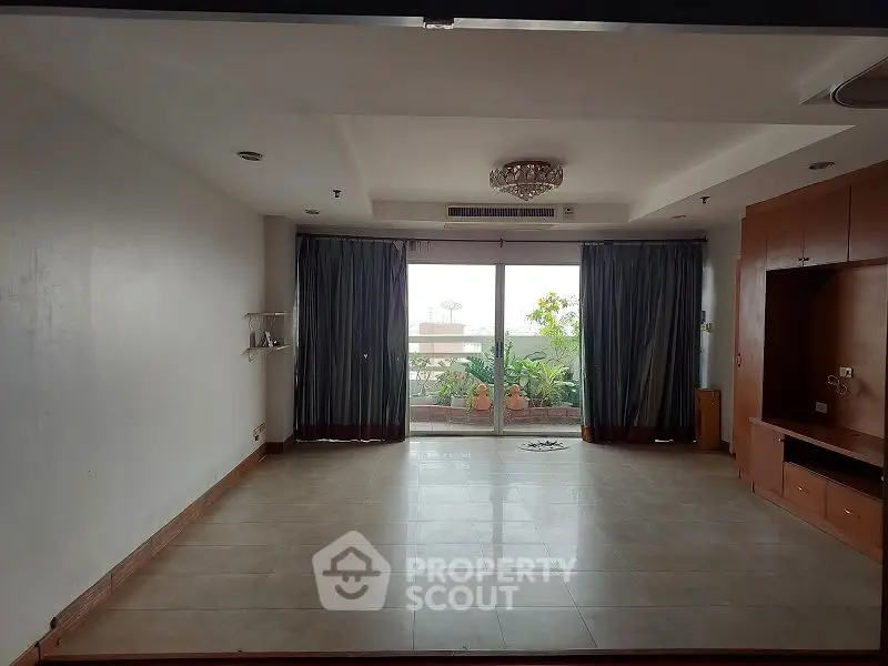 Spacious living room with large windows and built-in shelving, perfect for modern living.