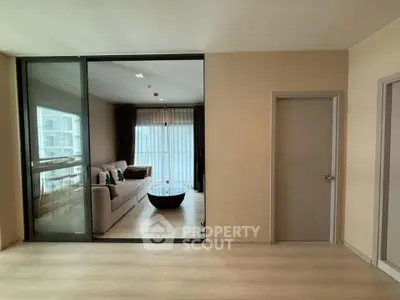 Modern living room with glass sliding door and cozy sofa in a stylish apartment.