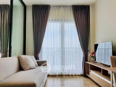 Modern living room with large window and elegant curtains, featuring a cozy sofa and sleek TV stand.
