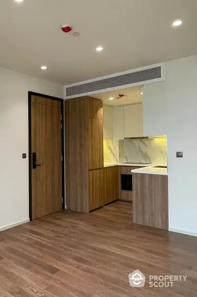 Modern kitchen with wooden cabinetry and sleek design in a contemporary apartment.