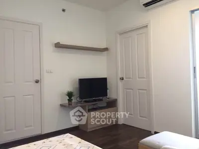 Modern living room with minimalist decor and wall-mounted TV in a cozy apartment.