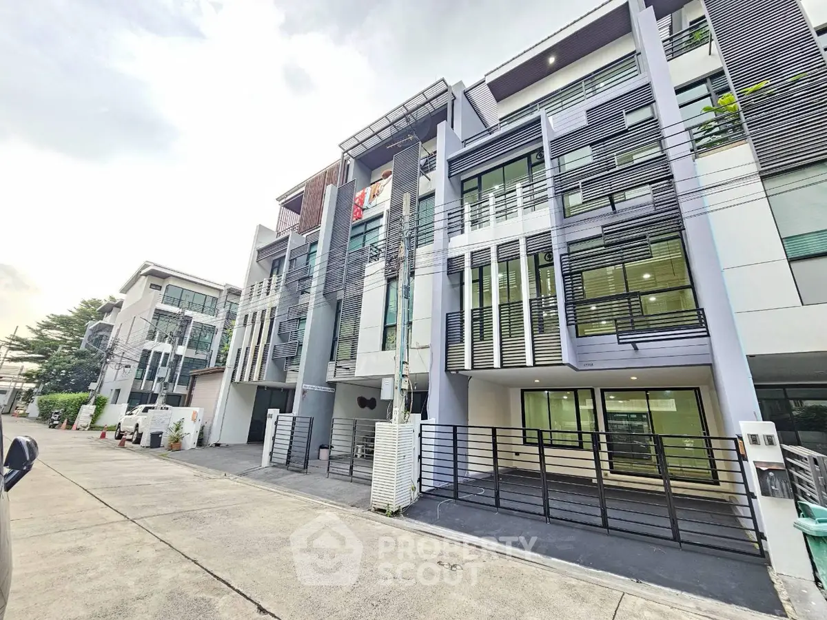 Modern multi-story residential building with sleek design and large windows in urban setting.