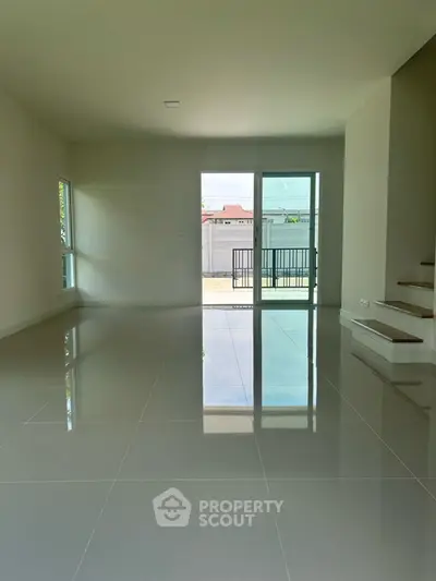 Spacious modern living room with glossy tile flooring and large windows for natural light.