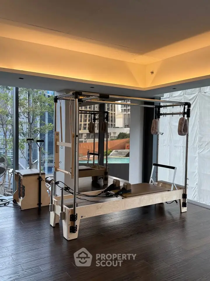Modern gym with pilates equipment and city view, perfect for fitness enthusiasts seeking luxury amenities.