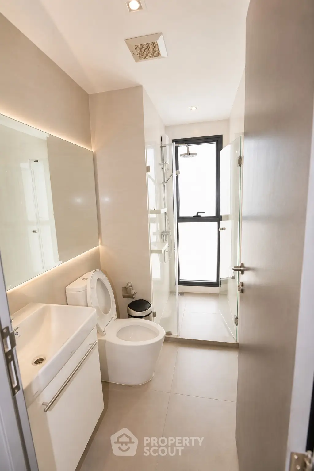 Modern bathroom with sleek fixtures and glass shower enclosure in a contemporary apartment.