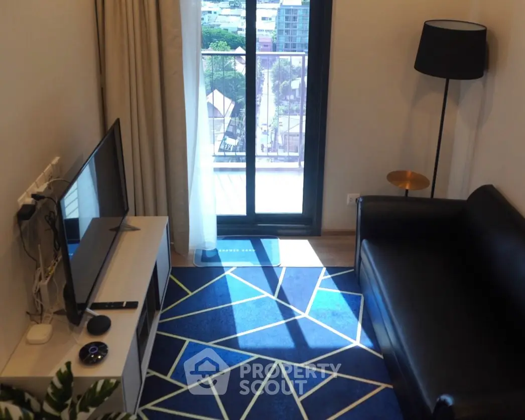 Modern living room with balcony view, stylish decor, and natural light.