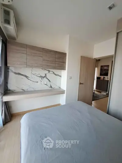 Modern bedroom with stylish marble accent wall and sleek wooden cabinetry, offering a serene and elegant living space.