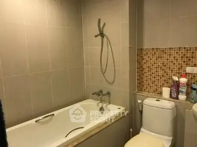 Modern bathroom with bathtub and tiled walls in a stylish apartment.
