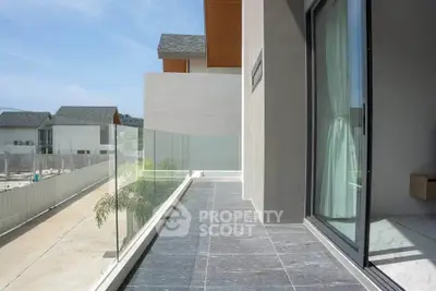 Modern balcony with glass railing and scenic view in contemporary home