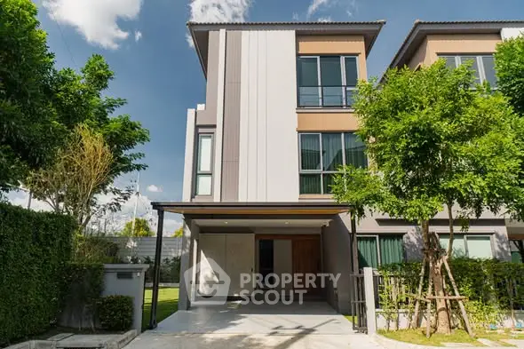 Modern three-story townhouse with sleek design and lush greenery
