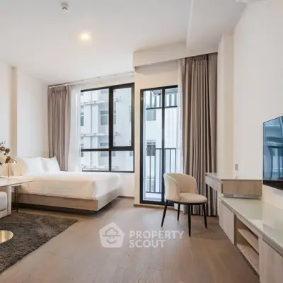 Modern studio apartment with large windows and stylish furnishings