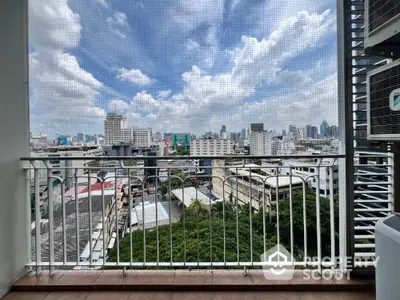 Stunning cityscape view from a high-rise balcony with clear blue skies.