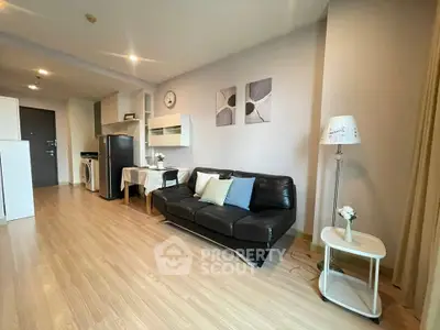 Modern living room with sleek black sofa and stylish decor in open-plan apartment