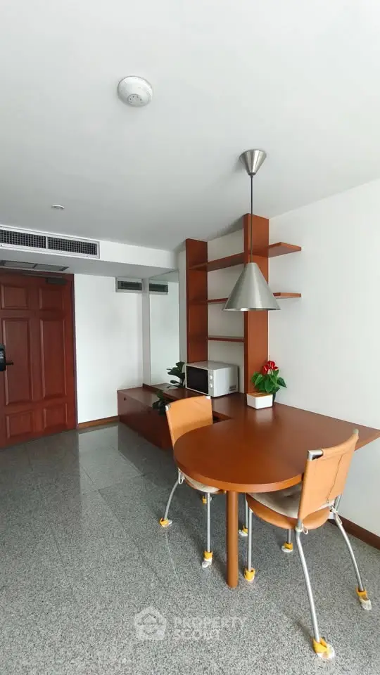 Modern dining area with stylish wooden furniture and sleek lighting in a contemporary apartment.