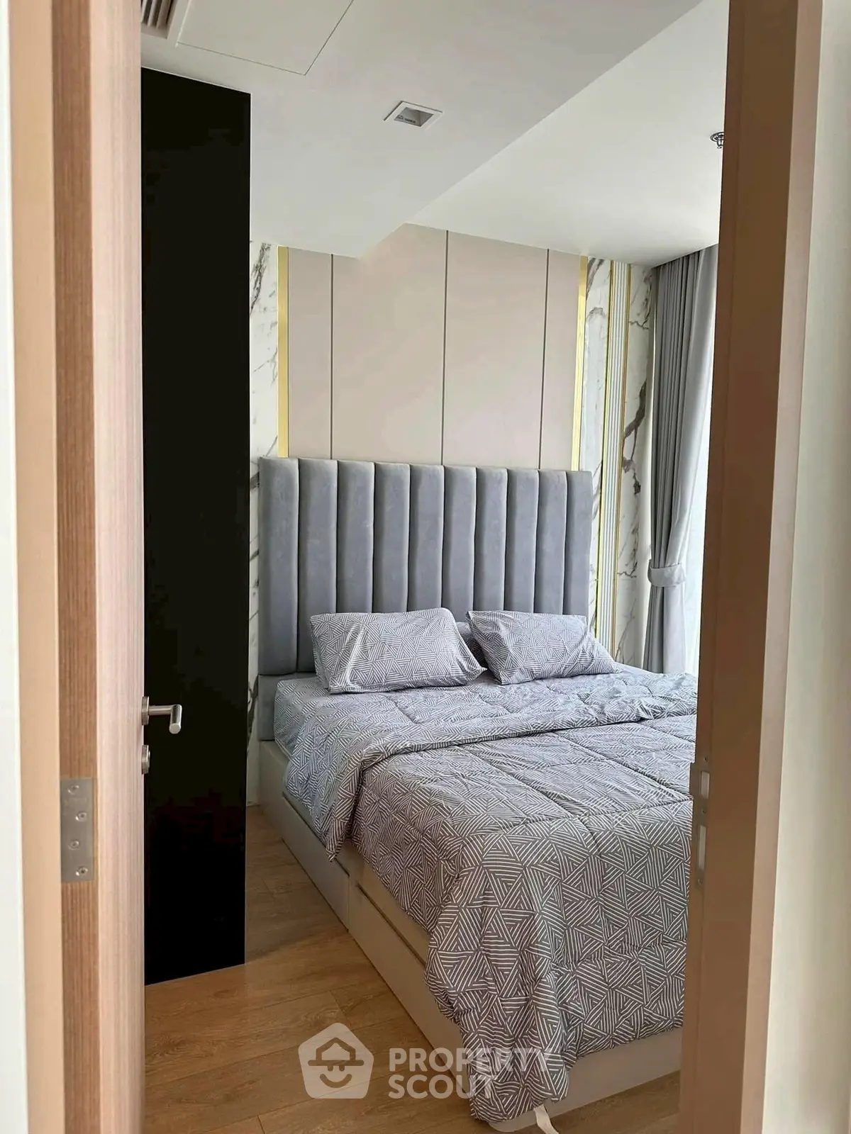 Modern bedroom with stylish decor and natural light, featuring a plush bed and elegant curtains.