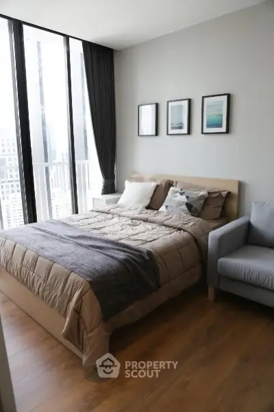 Modern bedroom with large windows and stylish decor in a high-rise apartment.