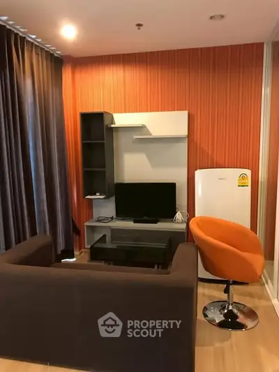 Modern living room with orange accent wall and cozy seating area.