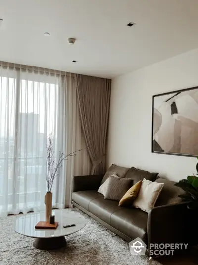 Elegant living room with plush seating, modern art, and floor-to-ceiling windows draped with stylish curtains, creating a serene urban oasis.