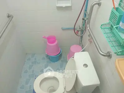 Compact bathroom with essential fixtures and colorful accessories