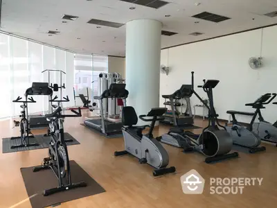 Spacious gym with modern exercise equipment and natural lighting