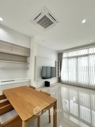 Modern living room with sleek furniture and large windows for natural light.