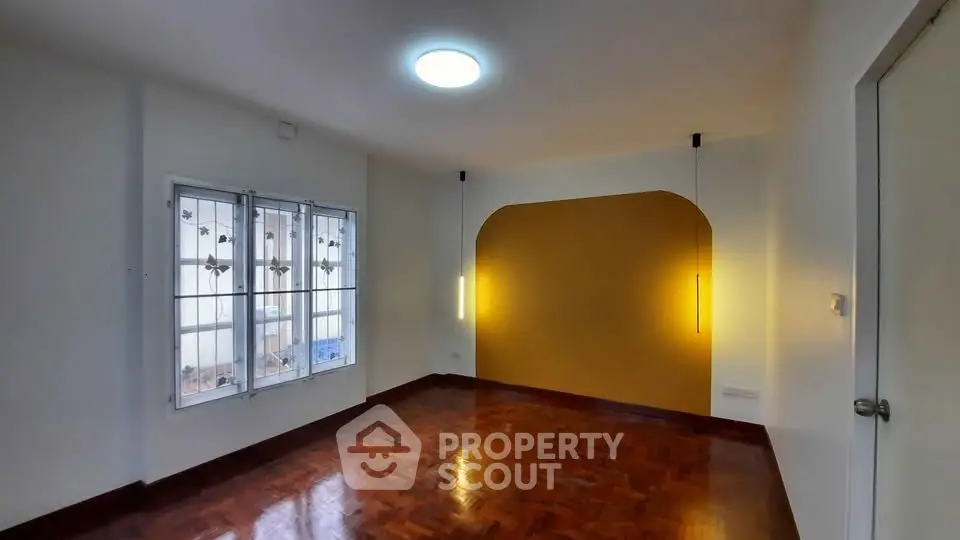Charming room with wooden flooring and stylish lighting, perfect for a cozy living space.