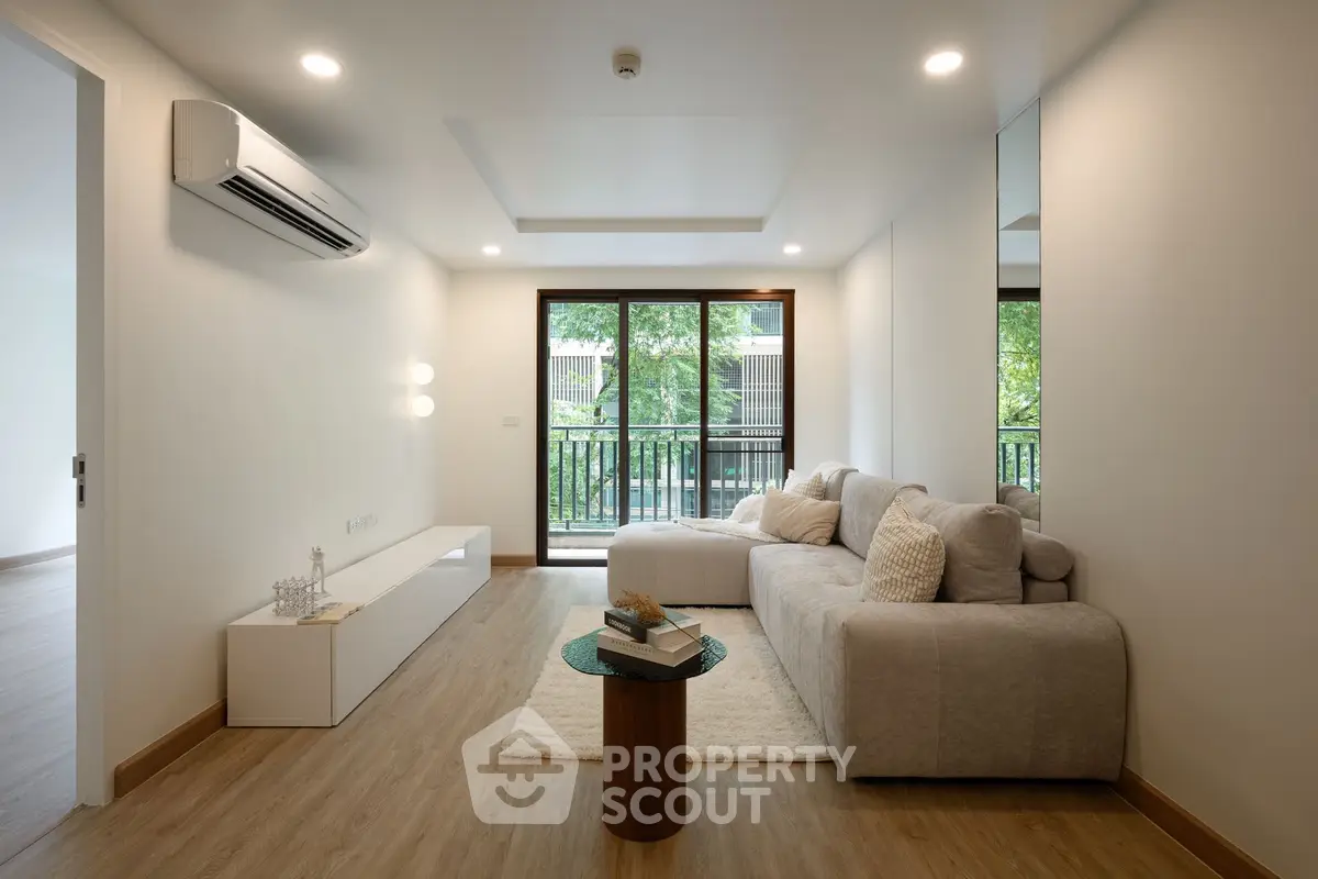 Modern living room with cozy sofa and large window overlooking greenery