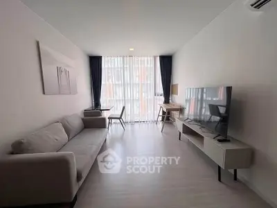 Modern living room with sleek furniture and large window for natural light.