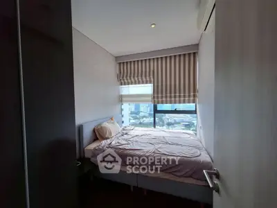 Cozy bedroom with city view and modern decor in high-rise apartment