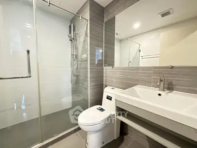 Modern bathroom with glass shower and sleek fixtures in contemporary apartment
