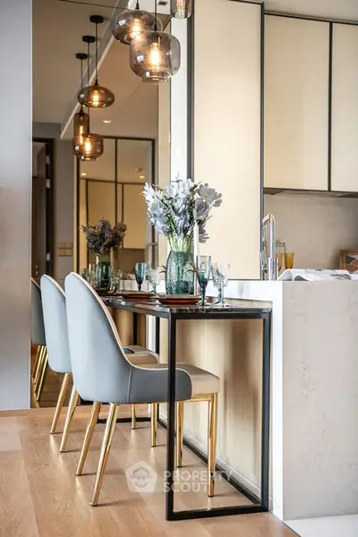 Modern kitchen with elegant dining area, featuring stylish chairs and contemporary lighting.
