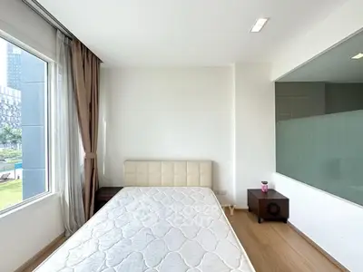 Modern bedroom with large window and minimalist decor in a bright apartment.