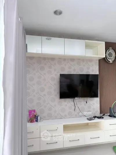 Modern living room with wall-mounted TV and stylish cabinetry